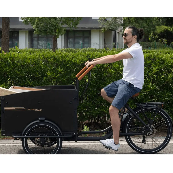 Man riding the Aitour Electric Cargo Bike Starter 250W with wooden cargo box on the front, designed for carrying loads with ease.