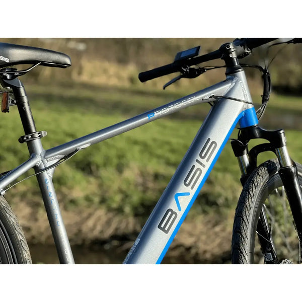 Detail shot of the Basis Protocol Electric Hybrid Mountain Bike 250W frame with visible branding and integrated battery tube.