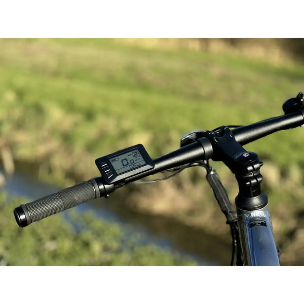Landscape view of the Basis Protocol Electric Hybrid Mountain Bike’s LCD handlebar display with assist level and speed readings.