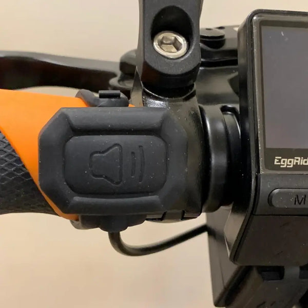 Close-up of handlebar-mounted remote button for Big Game Bikes 125dB electric bike horn and alarm.