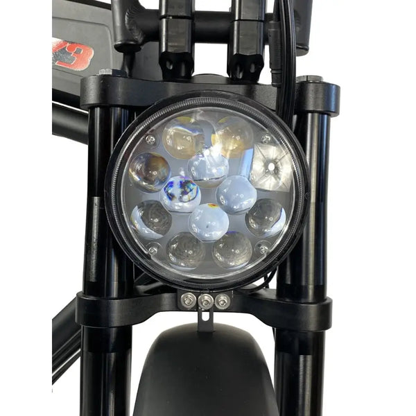 Close-up of the Cruz73 Unlimited Retro Fat Tyre 750W electric bike round LED headlight switched off.
