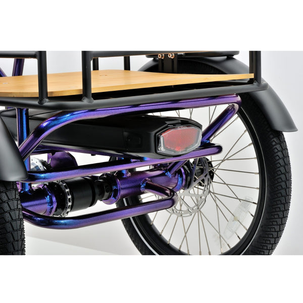 Rear view of the Revom T4 electric cargo tricycle highlighting the rear cargo rack, taillight, and disc brake on the right wheel.