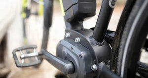 Close-up view of an electric bike mid-drive motor and pedal crank integrated into the frame.