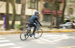 Cyclist riding a commuter electric bike through a city street in an urban environment