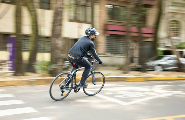 Cyclist riding a commuter electric bike through a city street in an urban environment