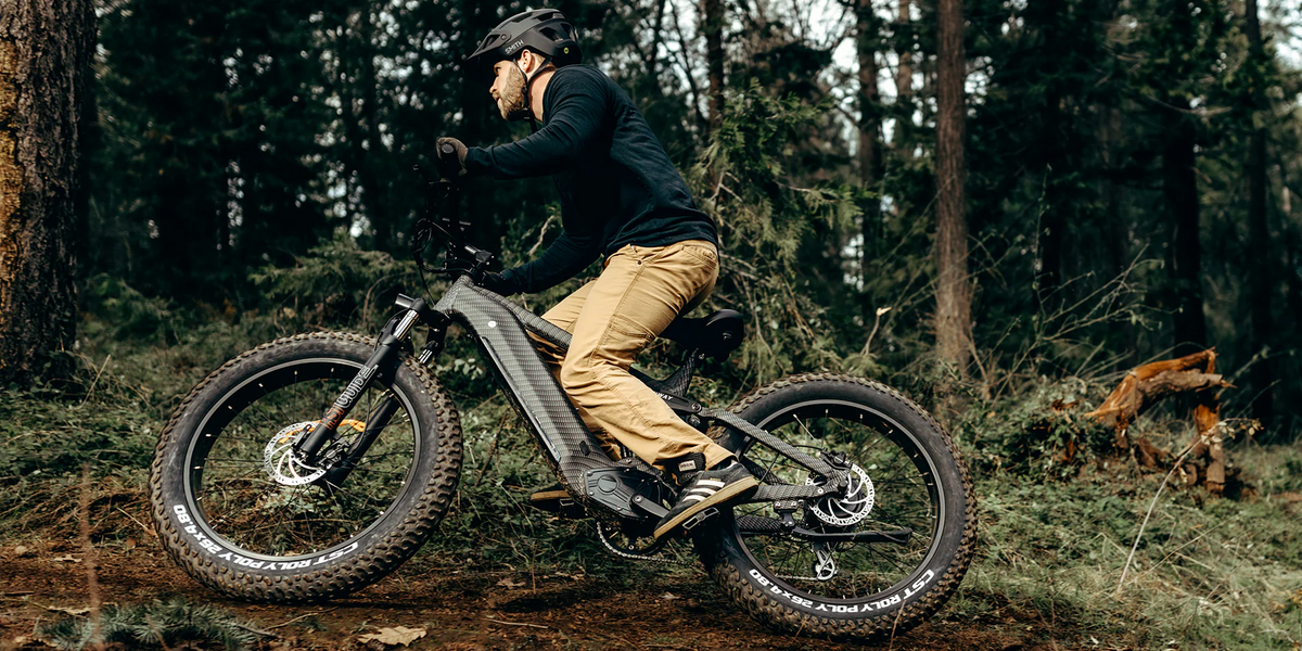 Rider using a fat tyre electric bike on a forest trail, highlighting stability, grip, and versatility for commuting and off-road use