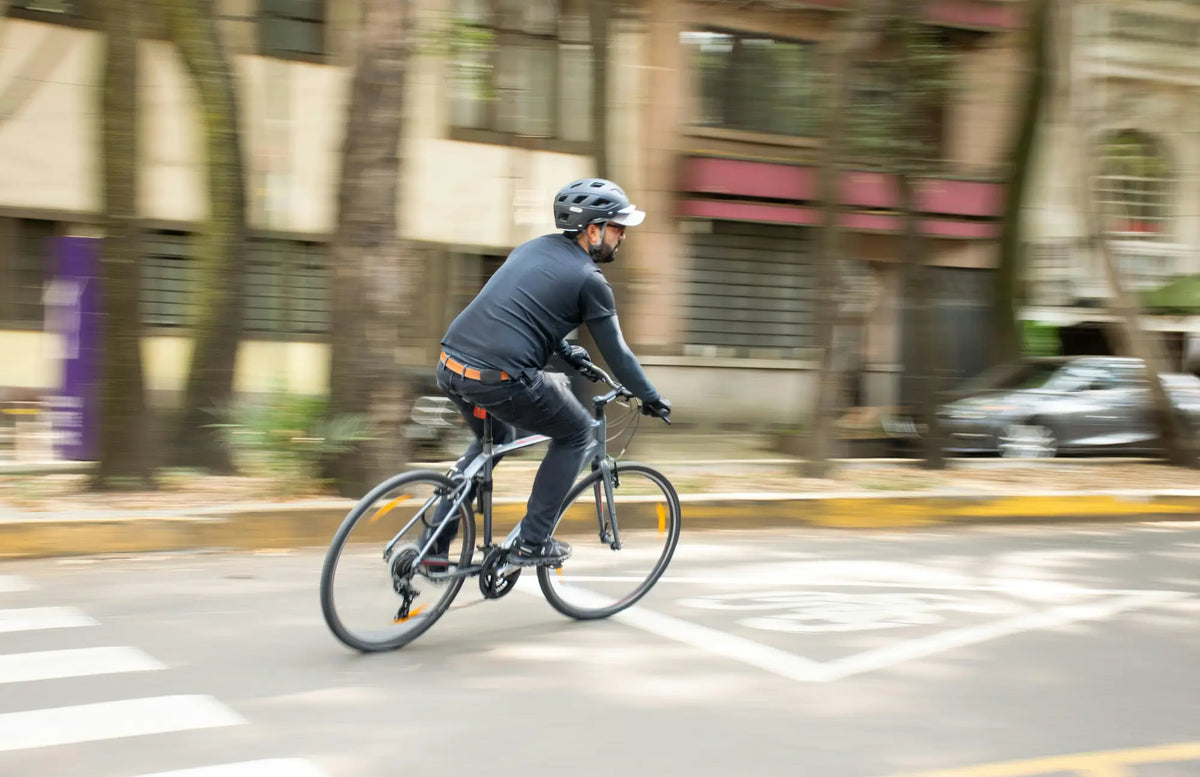 Electric bike ownership costs - cyclist riding a commuter e-bike through a UK city street