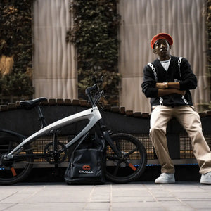 An urban cyclist beside his e-bike, highlighting a high-value premium e-bike that owners should insure against theft and accidental damage.