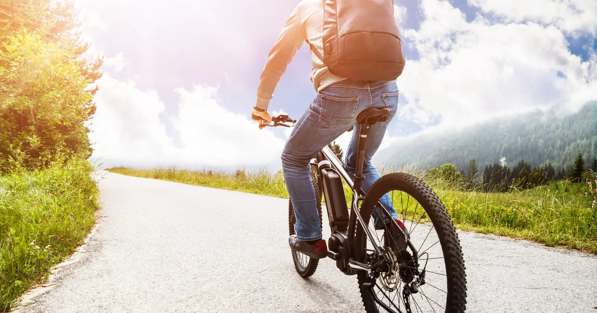 Person riding an electric bike on a public road, illustrating that legal e-bikes can be used without a driving licence in the UK