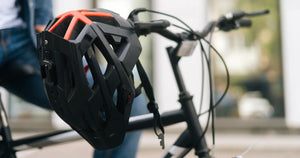 Protective cycling helmet hanging on electric bike handlebars, highlighting essential safety gear for e-bike riders.