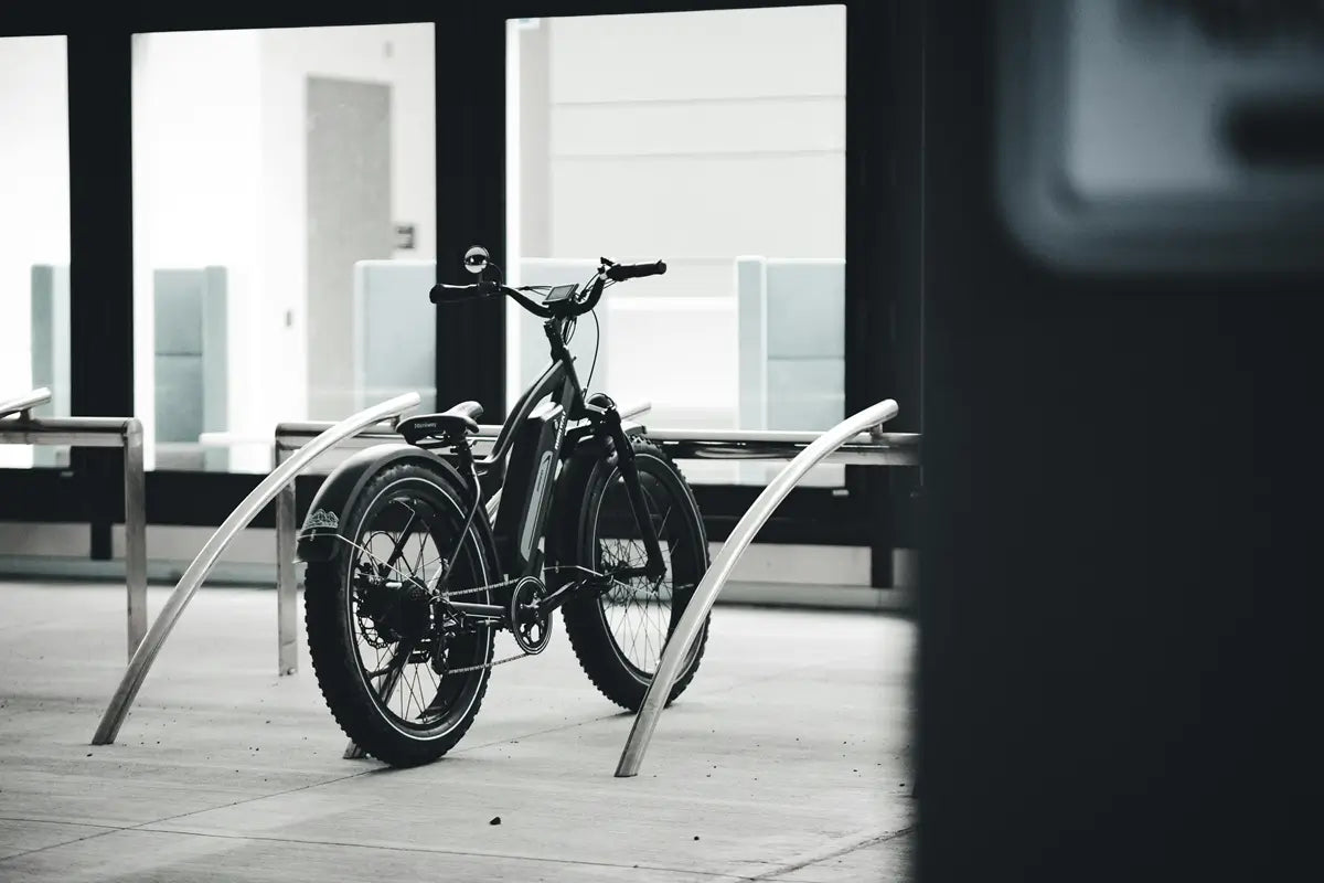 Electric bike secured at a modern bike rack in an urban setting, highlighting theft prevention and insurance importance.