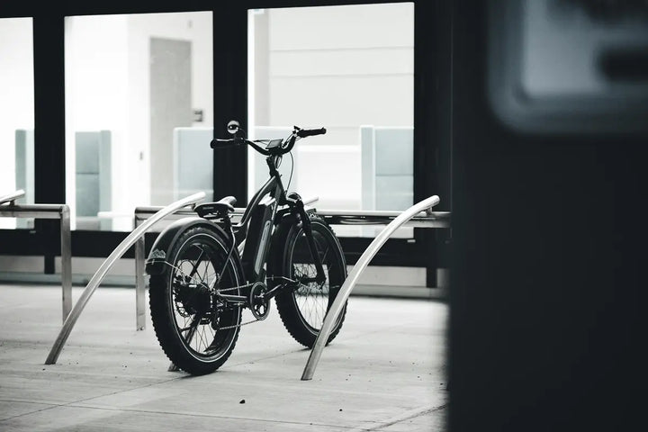 Electric bike secured at a modern bike rack in an urban setting, highlighting theft prevention and insurance importance.