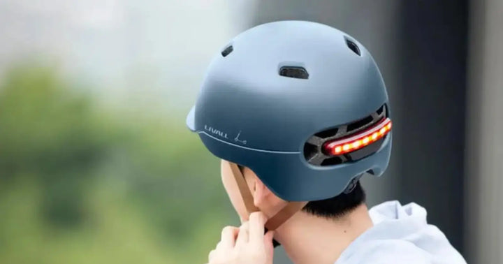 Livall smart cycling helmet with integrated rear LED light for improved visibility and safety while riding an electric bike.