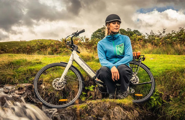 Rider sitting beside her electric bike, showcasing practical ebikes under £1000 for everyday riding.