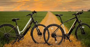 Mark x-cross electric bikes positioned on a countryside road at sunset with open fields stretching into the distance