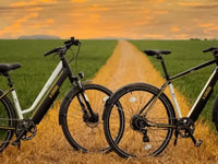 Two touring electric bikes parked on a countryside road at sunset in the UK