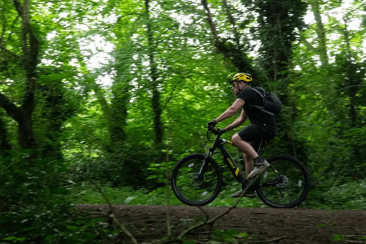 Rider using an electric mountain bike on a forest trail, showcasing off-road e-bike performance