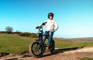 Rider sitting on a fat tyre electric bike on a countryside trail under a clear blue sky