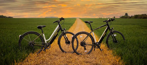 Two road-legal electric bikes parked on a countryside path suitable for commuting and leisure riding