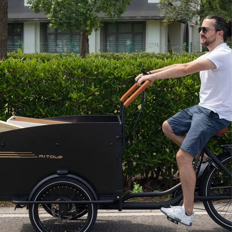 Man riding the Aitour Electric Cargo Bike Starter 250W with wooden cargo box on the front, designed for carrying loads with ease.