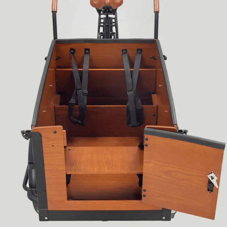 Interior view of the Family S wooden cargo box, showcasing the bench seating arrangement, safety straps, and the open front door for easy access.