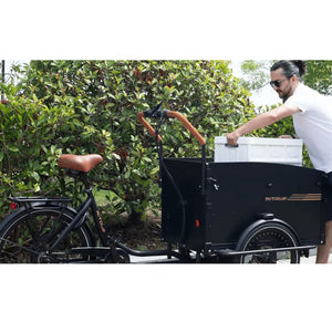Man loading a white box into the cargo compartment of the Aitour Electric Cargo Bike Starter 250W, built for practical transport and daily use.