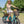 Woman cycling the Aitour Heal Mini folding electric trike loaded with flowers and groceries in the baskets.