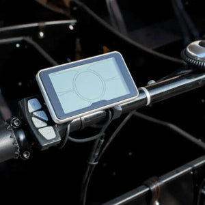 Close-up of the handlebar-mounted LCD display screen and control buttons on the Amcargobikes Curve.