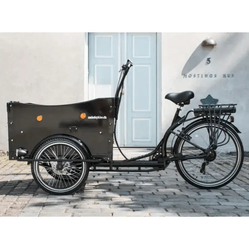 Side profile of the black Amcargobikes Curve cargo trike showing the spacious wooden box and ergonomic handlebars.