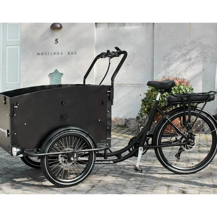 Front-left angled of the Amcargobikes Ultimate Curve cargo trike, showcasing the spacious black cargo box and stable three-wheel design.