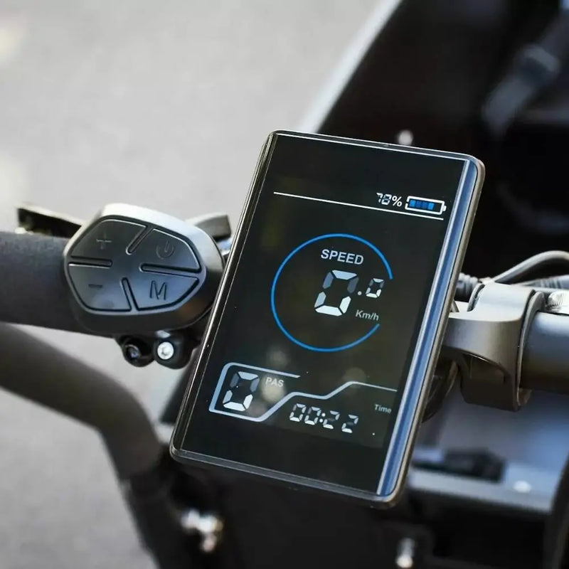 Digital LCD display screen on the handlebars of an Amcargobikes Ultimate Curve cargo e-bike, showing speed, battery level, and pedal assist settings.