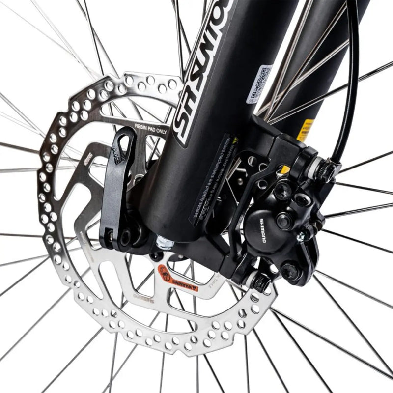 Close-up of the Shimano hydraulic disc brake caliper mounted on the SR Suntour suspension fork.
