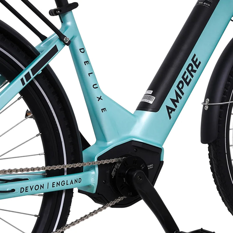 Close-up of the mid-drive motor housing and integrated downtube battery on the light blue Ampere Deluxe Pro electric bike.