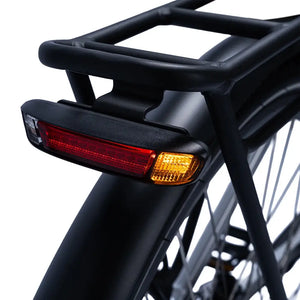 Close-up of the Ampere Deluxe integrated rear light unit on black pannier rack showing red and amber LEDs.