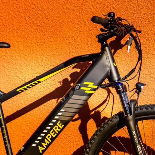 Close-up of Ampere X-Trail electric mountain bike frame and suspension fork with integrated battery and high torque motor.
