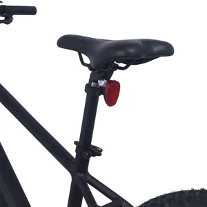 Close-up of the Ampere X-Trail black saddle and seatpost with red rear safety light.