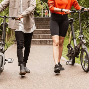 Two people walking outdoors with their Axon Rides Pro Lightweight Folding Electric Bikes 250W, ideal for urban mobility.