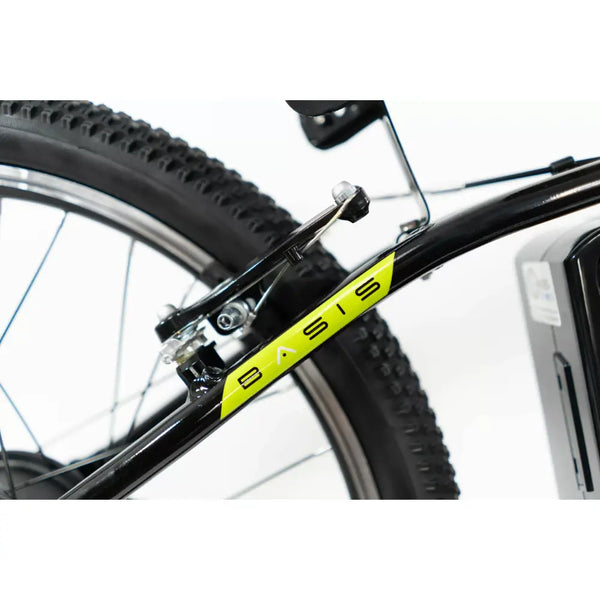 Close-up of the V-brake cable routing and Basis logo decal on the e-bike frame.