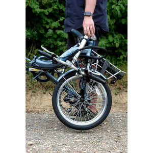 Folded Basis Osprey Low Step Folding Electric Bike 250W being carried by a person, showcasing its portability and compact design.