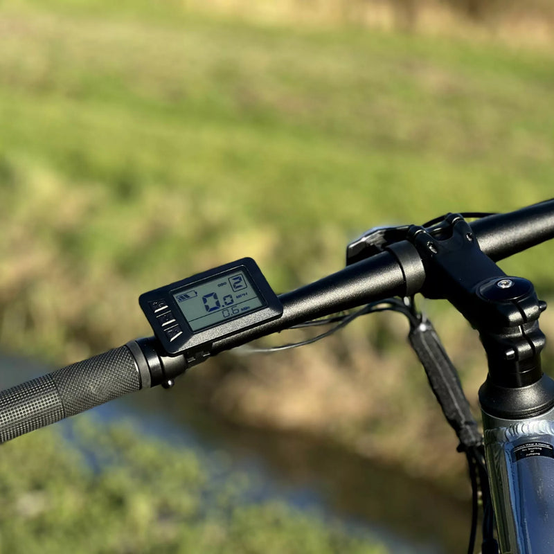 Landscape view of the Basis Protocol Electric Hybrid Mountain Bike’s LCD handlebar display with assist level and speed readings.
