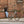Man leaning on a brick wall checking his phone next to a parked grey Batribike Tour X