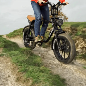 Rider on the Big Game Bikes Warthog Fat Tyre Cruiser Electric Bike going downhill on an off-road trail, highlighting its rugged tyres and cruiser frame.