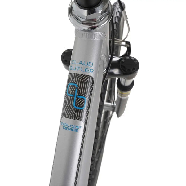 Close-up of the CLAUD BUTLER and EXPLORER SERIES logos on the down tube of the silver low-step hybrid bike.