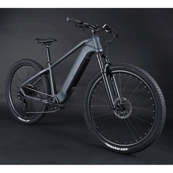 Angled side profile of the Claud Butler Wrath 1.0 Cues electric mountain bike, showcasing its sleek integrated battery, hardtail frame, and off-road ready 29-inch wheels.