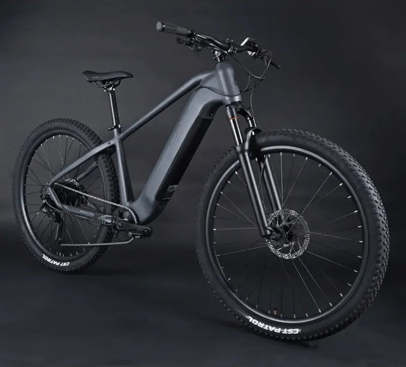 Angled side profile of the Claud Butler Wrath 1.0 Cues electric mountain bike, showcasing its sleek integrated battery, hardtail frame, and off-road ready 29-inch wheels.