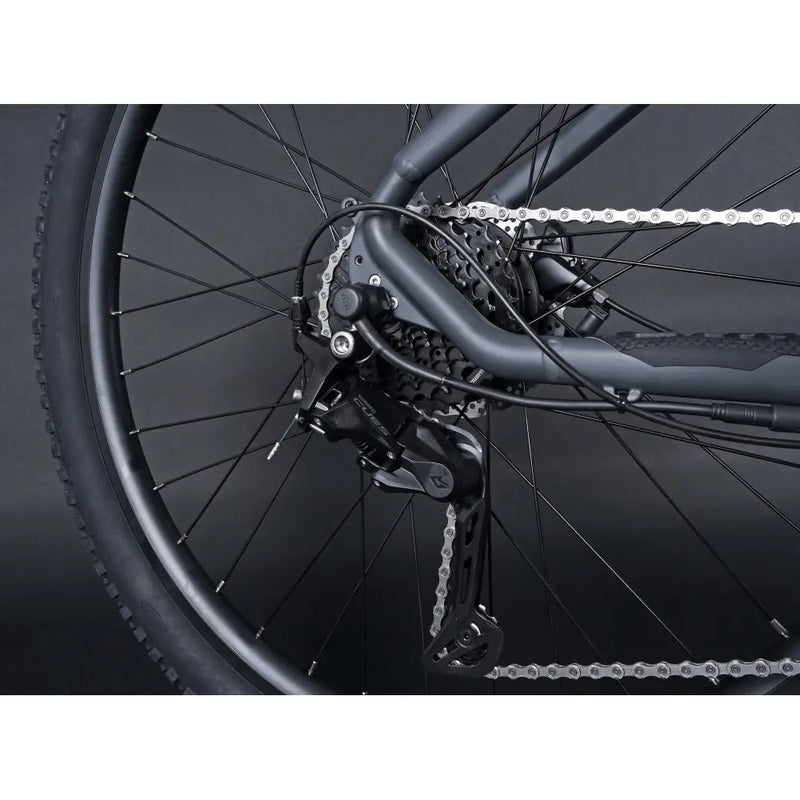 Rear derailleur and cassette of the Claud Butler Wrath 1.0 Cues electric mountain bike, highlighting the gear system and chain detail.