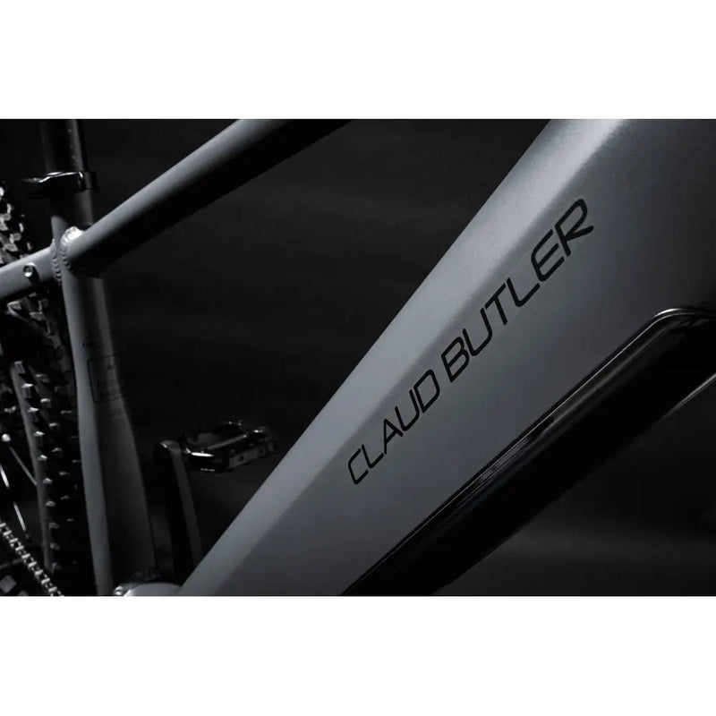 Close-up of the grey alloy downtube on the 2025 Claud Butler Wrath 1.0 electric mountain bike, featuring the bold black brand logo and integrated battery compartment.