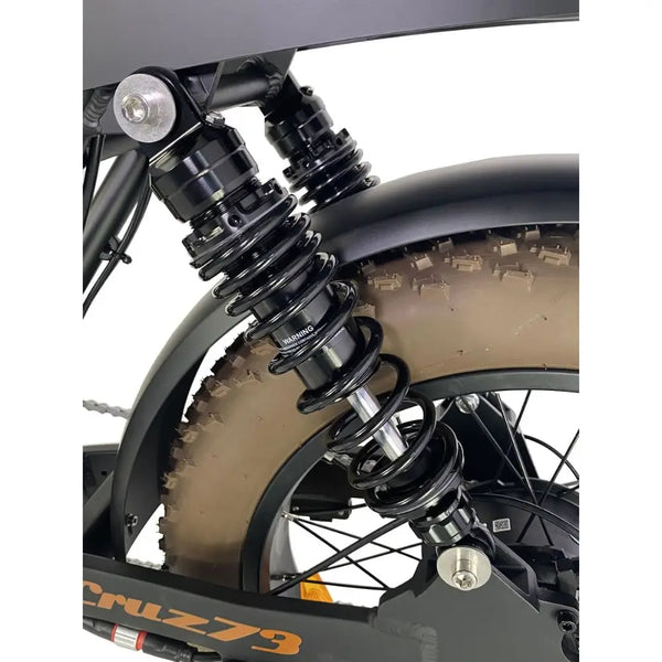 Close-up of the Cruz73 Mariner Retro Special Edition electric bike twin rear shock absorbers above the fat tyre.