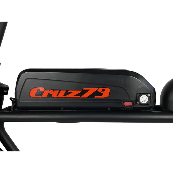 Close-up of the Cruz73 Pro Retro Fat Tyre Electric Bike 250W battery with Cruz73 branding in bold orange letters on a black casing.