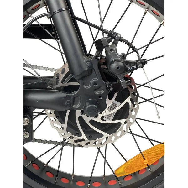 Close-up view of the disc brake system on the Cruz73 Retro Fat Tyre Electric Bike, showing detailed caliper and rotor design for powerful stopping performance.